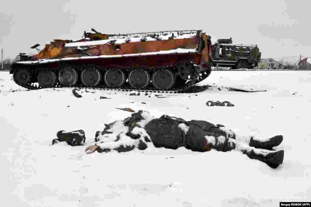 The body of a Russian serviceman lies near destroyed Russian military vehicles on a roadside on the outskirts of Kharkiv in northern Ukraine.