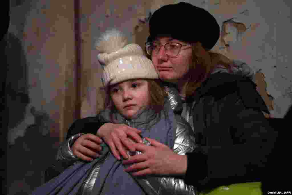 Helga Tarasova își îmbrățișează fiica într-un adăpost subteran din Kiev în dimineața din 26 februarie. Mii de locuitori din Kiev și Harkov se ascund în fiecare zi în subsoluri sau în stațiile de metrou, unele dintre puținele locuri sigure când apar bombardamente.
