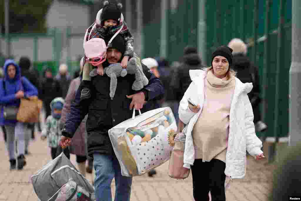 At Medyka, Poland, a family crosses the border on February 25 after fleeing the fighting.