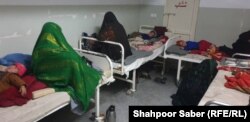 Mothers sit with their children in a measles ward of a Badghis hospital.