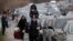 Ukrainian refugees walk alongside vehicles lining-up to cross the border from Ukraine into Moldova on February 26.