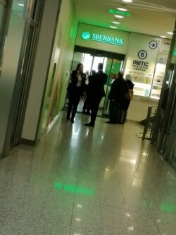 Sarajlije ispred ulaza u ekspozituru Sbebanke u zgradi UNITIC-a, u centru grada, čekaju da povuku gotovinu, 25. februara 2022. BiH je jedna od država u kojima je ova donedavno ruska banka prodata AIK banci iz Srbije. Tranzicija bi trebalo da bude okončana do kraja 2022.