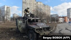Боєць тероборони оглядає знищену російську військову техніку в Харкові, 27 лютого 2022 року