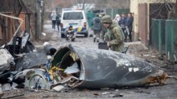 Un militar ucrainean inspectează resturile unui avion, Kiev, 25 februarie 2022.