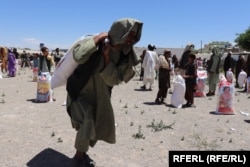 A man carries a bag of wheat flour he received from the WFP in the southern province of Uruzgan in March.
