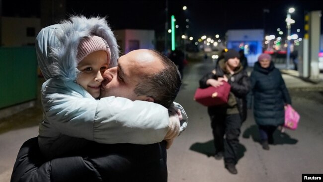 Një baba puth vajzën e tij pasi ajo, nëna dhe gjyshja ikën nga pushtimi rus dhe kaluan kufirin në Medyka, Poloni më 27 shkurt 2022. Reuters/Bryan Woolston