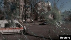  Линейка в Киев се вижда през продупчен от снаряди прозорец. На осмия ден от съветската инвазия в Украйна столицата на страната остава под украински надзор. 