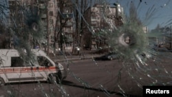  Линейка в Киев се вижда през продупчен от снаряди прозорец. На осмия ден от съветската инвазия в Украйна столицата на страната остава под украински надзор. 