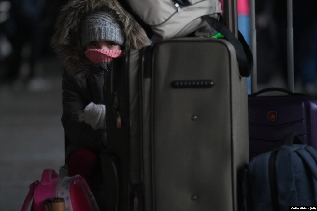 Дитина сидить на валізі, очікуючи на посадку на потяг до Львова. Київ, 28 лютого 2022 року