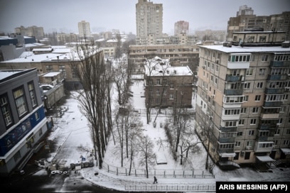 A man walks on the snow-covered pavement in an empty street of Kyiv a week after Russia launched its invasion of Ukraine in February.