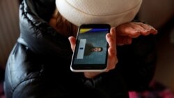 Žena sluša govor predsednika Ukrajine u izbeglištvu u Beregsuraniju, Mađarska, 28. februar