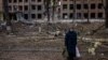 Жінка на тлі зруйнованої російськими обстрілами будівлі у Василькові Київської області, 27 лютого 2022 року