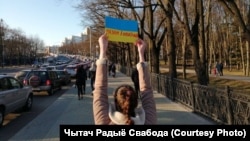 A woman holds up a protest sign against Russian aggression in Ukraine in Minsk on February 27. 