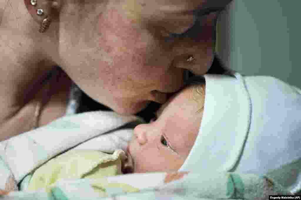 Катерина Сухарокова цілує свого новонародженого сина Макара. Хлопчик народився у підвалі пологового будинку, переобладнаного під медичне відділення і використовуваного як бомбосховище. Маріуполь, 28 лютого 2022 року