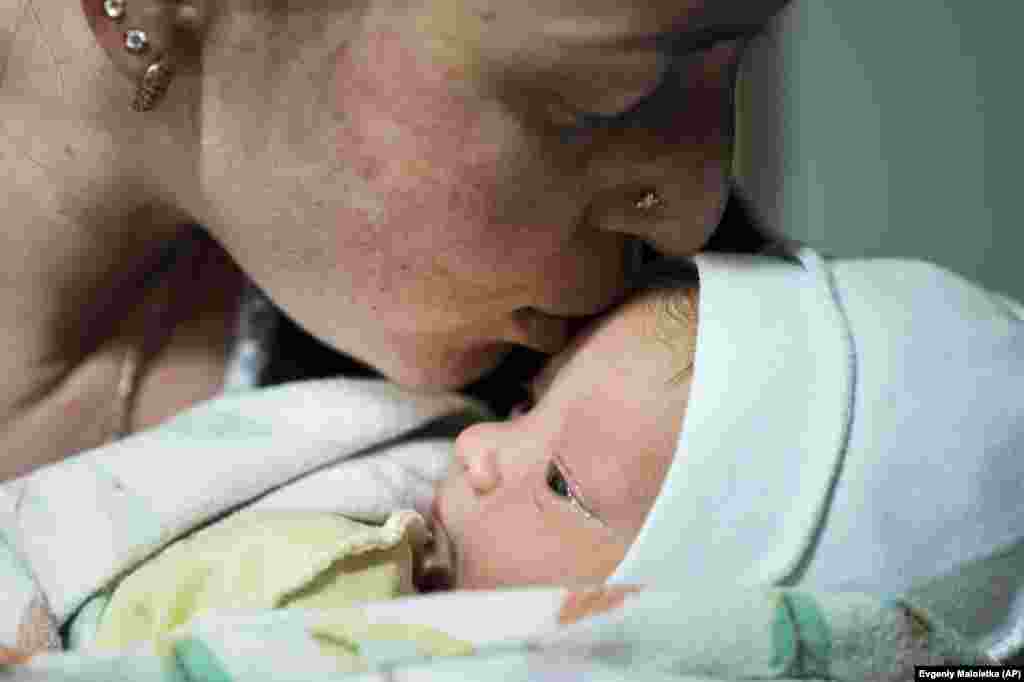 Kateryna Suharokova kisses her newborn son Makar in the basement of a maternity hospital converted into a medical ward and used as a bomb shelter in Mariupol on February 28.