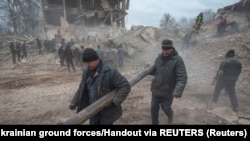  Украинци разчистват ударена военна база в Охтирка, област Суми. 