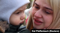 Peste 8 milioane de ucraineni au fost nevoiți să fugă din țara lor într-un an de război barbar. Numărul morților, răniților, al caselor, orașelor și vieților distruse e greu de estimat. (Foto: 1 martie 2022 - o femeie și copilul ei au ajuns la granița cu Polonia).