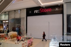 A woman walks past a closed 're:Store,' an Apple reseller shop at a mall in Saint Petersburg on March 2.