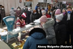 Покупатели выстраиваются в очередь у прилавка на рынке в Омске. Россия, 18 февраля 2022 года