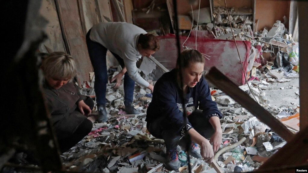 Луѓе во разурнат стан во зграда во градот Хорливка, за кој мештаните велат дека бил уништен при бомбардирање, 2 март 2022