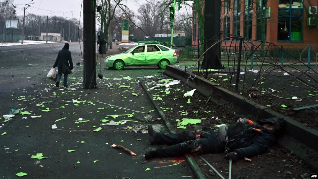 Жена поминува покрај телото на загинат во воздушните напади врз Киев, 1 март 2022