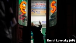 Žena u Sankt Petersburgu čeka u redu u menjačnici 25. februara 2022, dan nakon početka invazije na Ukrajinu. Građani Rusije su preplavili banke i pohrlili na bankomate nakon što je Zapad najavio i počeo sa sprovođenjem oštrih sankcija toj državi. 