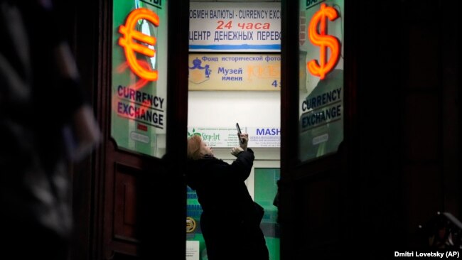 A woman stands in a currency exchange office in St. Petersburg.