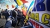 Romanian police push back protesters trying to enter the secured perimeter of the Romanian parliament headquarters during a demonstration in Bucharest on December 21.