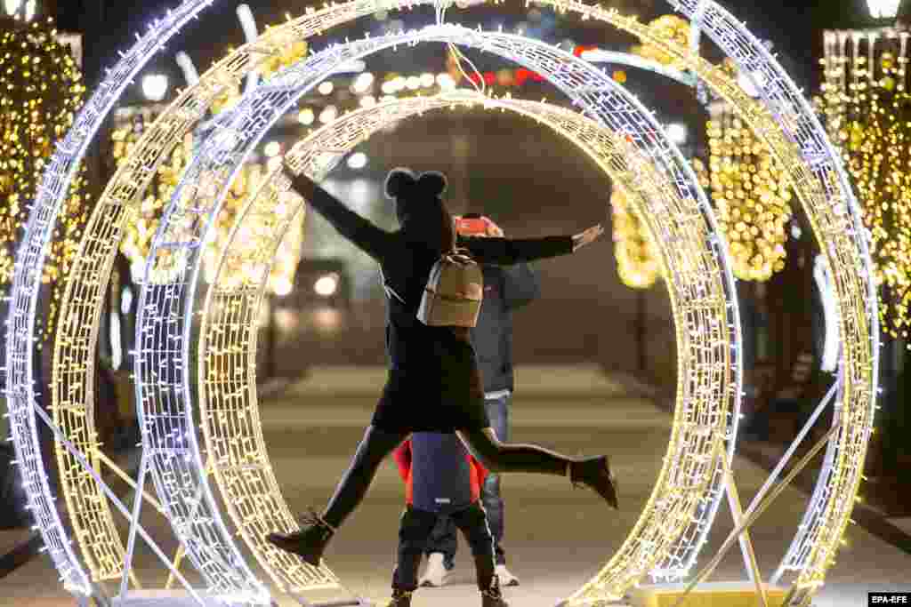 People have fun with an alleyway of Christmas lights in downtown Chisinau, Moldova.&nbsp;