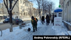 Работница коммунальной службы убирает снег на улице Большая Морская