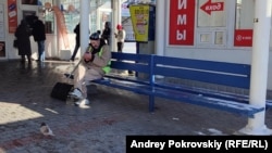 Дворник отдыхает после уборки остановки на улице Адмирала Юмашева