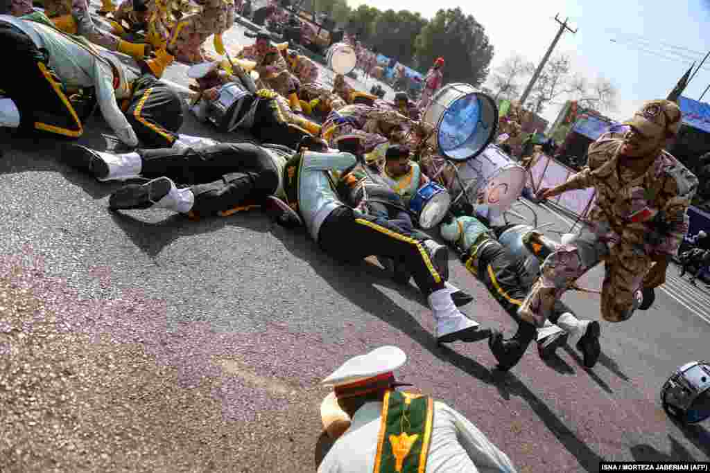 A soldier runs past injured comrades lying on the ground at the scene of an attack on a military parade in the southwestern Iranian city of Ahvaz on September 22. The parade marked the anniversary of the outbreak of the 1980-1988 war with Saddam Hussein's Iraq. Dozens of people were killed and dozens more were wounded in the attack, state media reported.(AFP/ISNA/Morteza Jaberian)