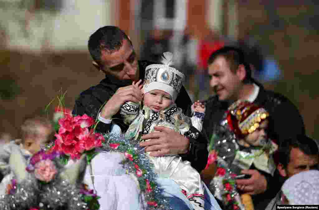 A Bulgarian Muslim man carries his son on a horse ahead of a mass circumcision ceremony in the village of Ribnovo.&nbsp;