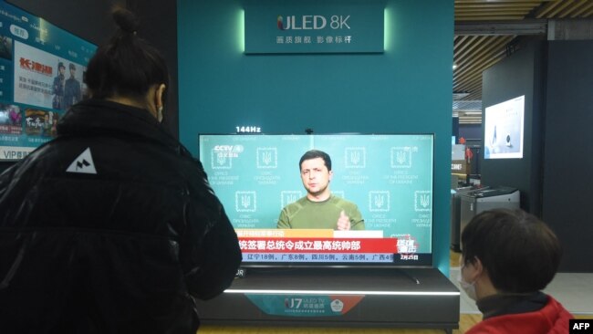 По китайска телевизия текат новини за руската инвазия в Украйна. Снимката е от търговски център в Хангжу в източен Китай, 25 февруари 2022 г.