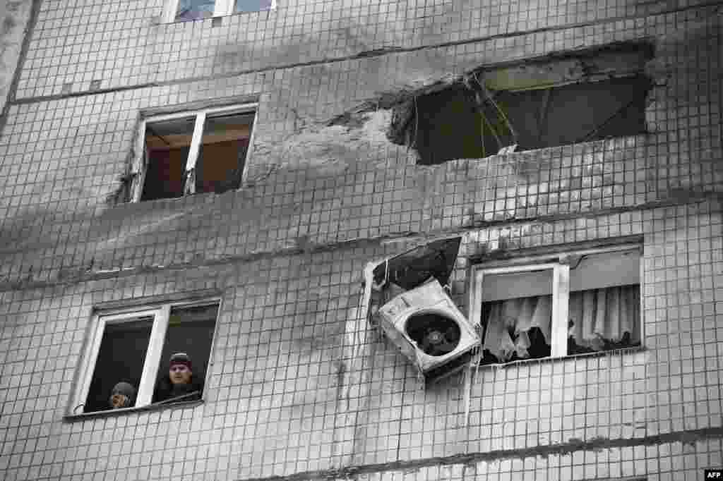 People look out a window after their building in the Telstilshik district of the eastern Ukrainian city of Donetsk was shelled. (AFP/Eric Feferberg)