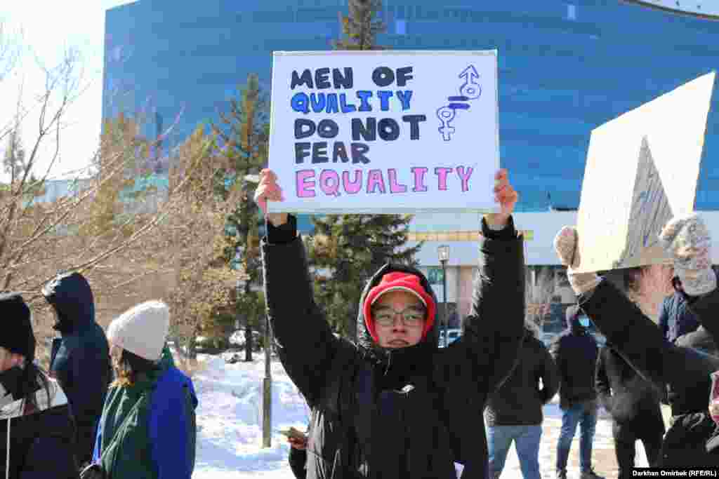 Молодой человек держит плакат &laquo;Сильные мужчины не боятся равенства&raquo;