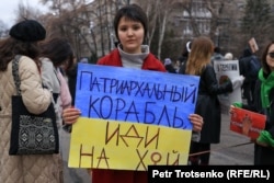 Участница митинга за права женщин в Алматы с плакатом. 8 марта 2022 года