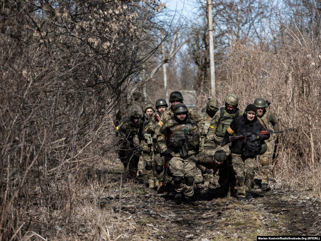 Forcat e Armatosura të Ukrainës mbajnë një shok të plagosur pasi sulmuan vendbanimin ku ndodhej ushtria ruse. Rajoni i Kievit, 10 mars 2022