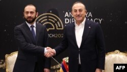 Turkish Foreign Minister Mavlut Cavusoglu (right) shakes hands with Armenian Foreign Minister Ararat Mirzoian in Antalya on March 12.