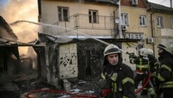 Vatrogasci na terenu nakon granatiranja u blizini Kijeva.