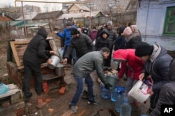 People line up to get water at a well on the outskirts of Mariupol on March 9.