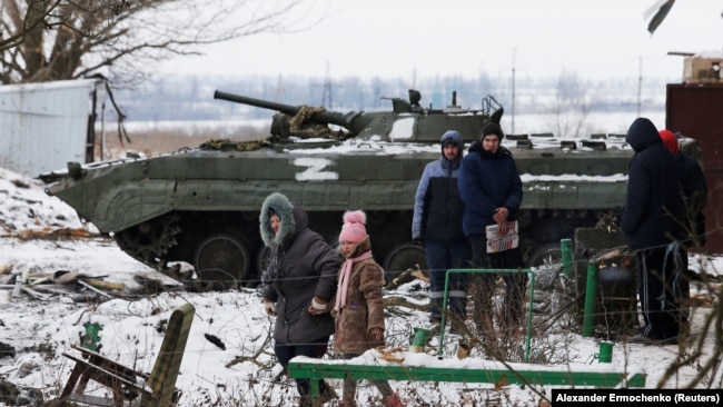 Disa civilë duke u larguar nga luftimet në një rajon të Ukrainës më 11 mars, 2022.