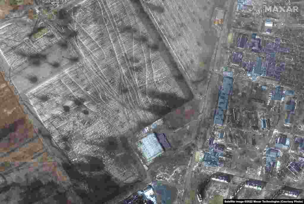 Multispectral imagery of artillery craters in fields and damaged buildings in the Zhovteneyvi district of western Mariupol.