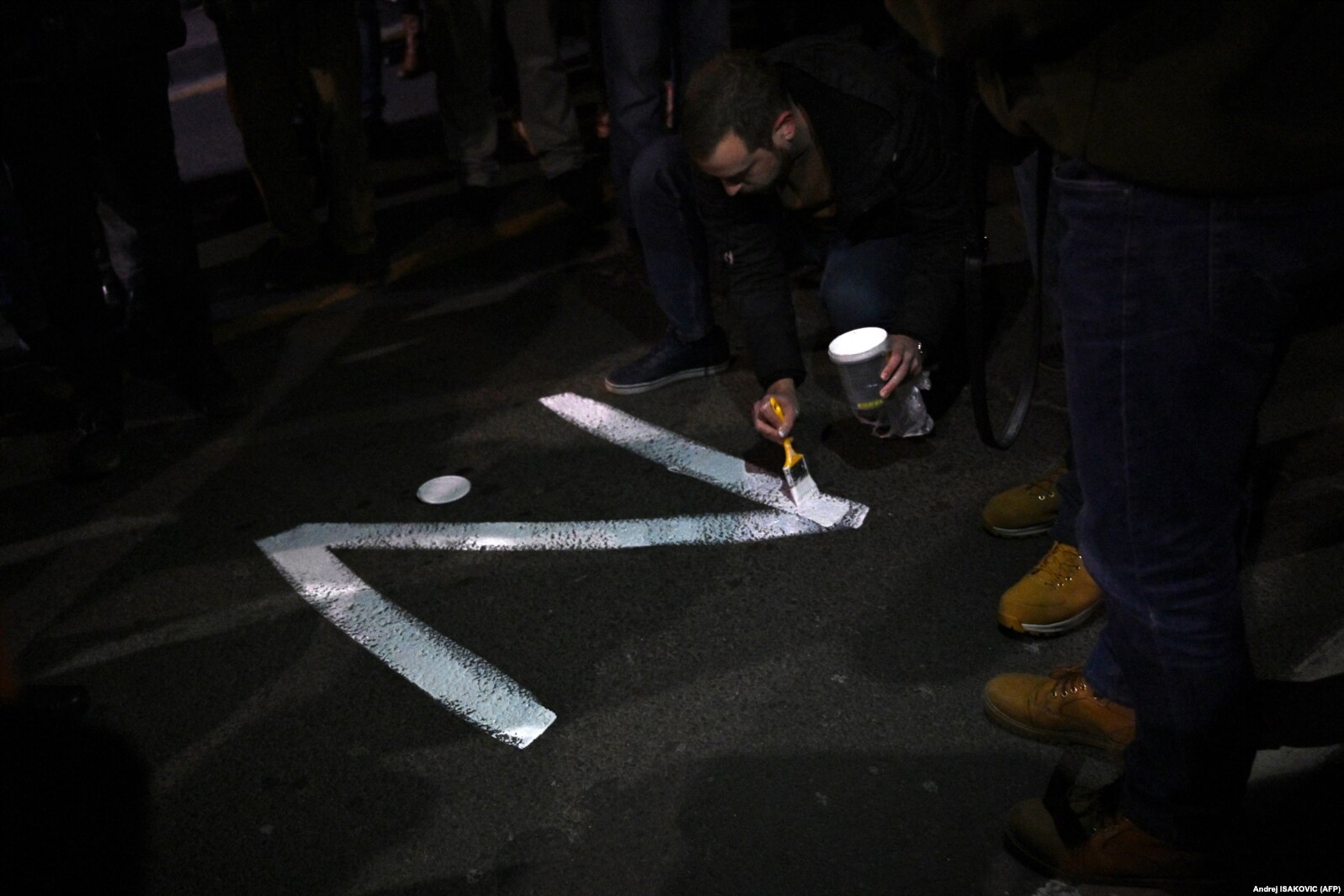 Një protestues në Serbi vizaton simbolin 'Z' në një rrugë të Beogradit.