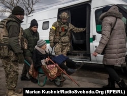 An elderly woman is put into a van assigned to evacuate civilians from Bucha in the Kyiv region on March 9.