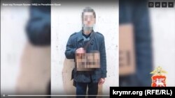 Крымчанин на одиночном пикете с антивоенным плакатом, содержание которого на видеоролике заретушировано российской полицией, март 2022 года