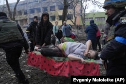 Українські рятувальники і волонтери несуть вагітну жінку, яка постраждала в результаті авіаційного удару російських військових по пологовому будинку та дитячій лікарні в Маріуполі, 9 березня 2022 року. Фото Євгена Малолєтки