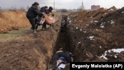 Жители на Мариупол погребват тела на убити в масови гробове. 9 март 2022 г.