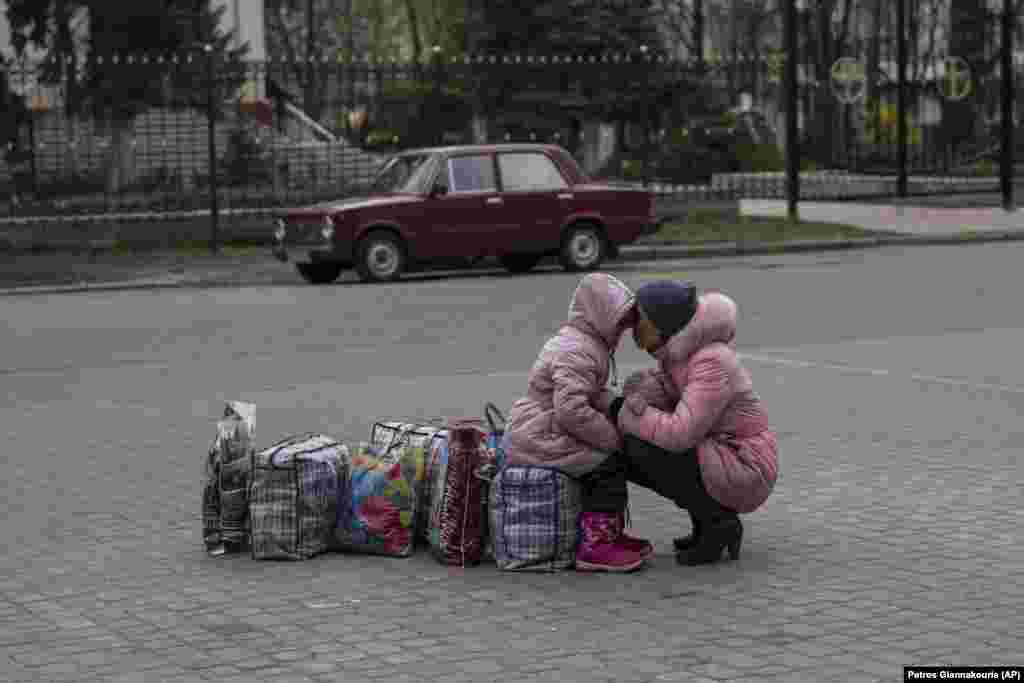 Egy anya öleli át lányát, miközben a buszukra várnak, amellyel a kelet-ukrajnai Szlovjanszkból az ország nyugati részén található Rivnébe menekülhetnek április 16-án