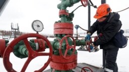Munkás kútfej ellenőrzése közben az Irkutszki Olajtársaság (INK) tulajdonában lévő Yarakta olajmezőn, az oroszországi Irkutszki régióban 2019. március 10-én.